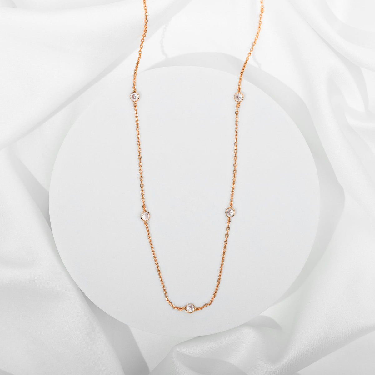 Avera diamond station necklace in rose gold - flat on silk