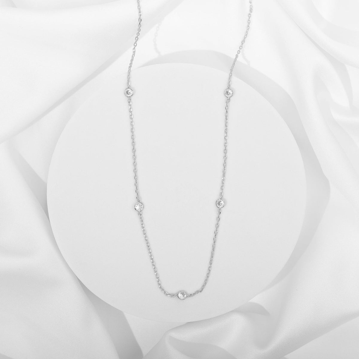 Avera diamond station necklace in white gold - flat on silk