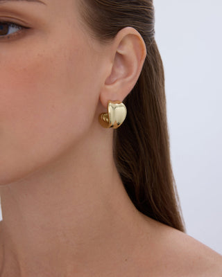 Gold hoop sitting straight on the lobe, front view