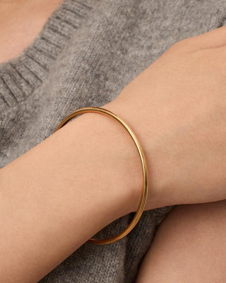 Gold hinged bangle bracelet worn on the wrist