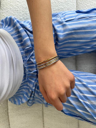 Gold and silver bangles stacked on the wrist