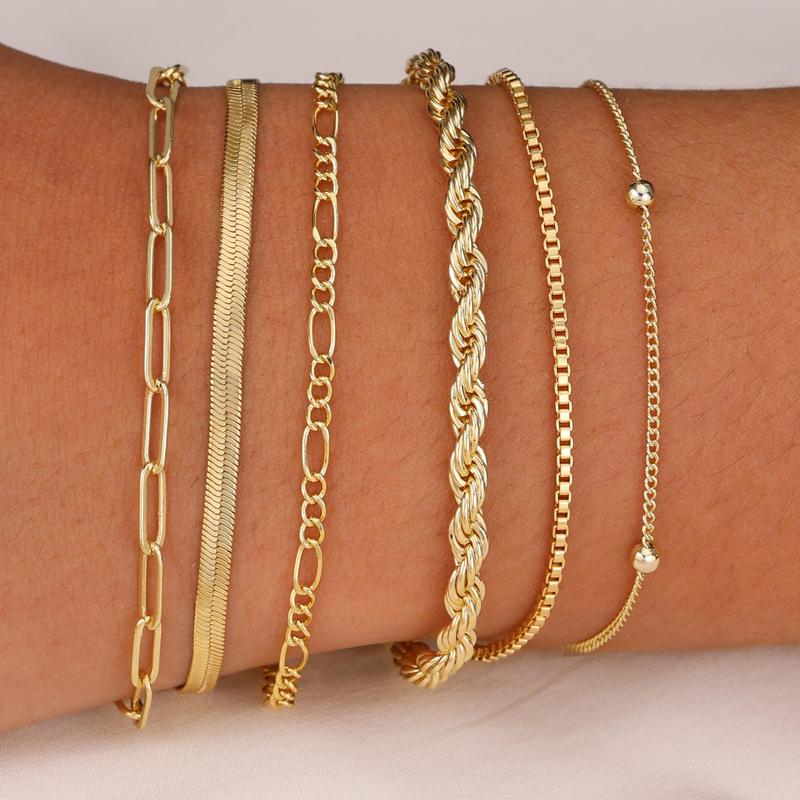 Six gold chain bracelets stacked on the wrist