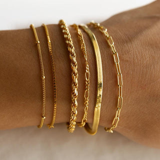 Six gold chain bracelets worn together