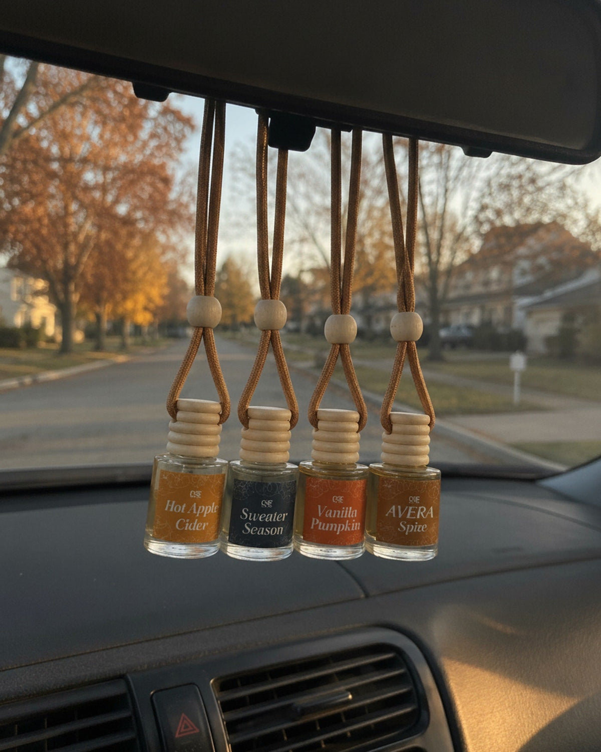 Four Avera car fresheners hanging from a rear-view mirror
