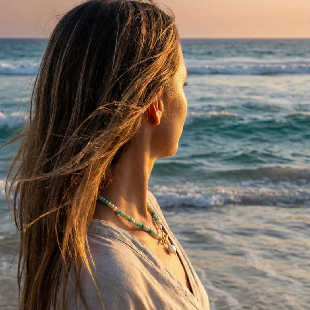 Woman at the shoreline at sunset wearing the Turquoise Bead Pearl Necklace