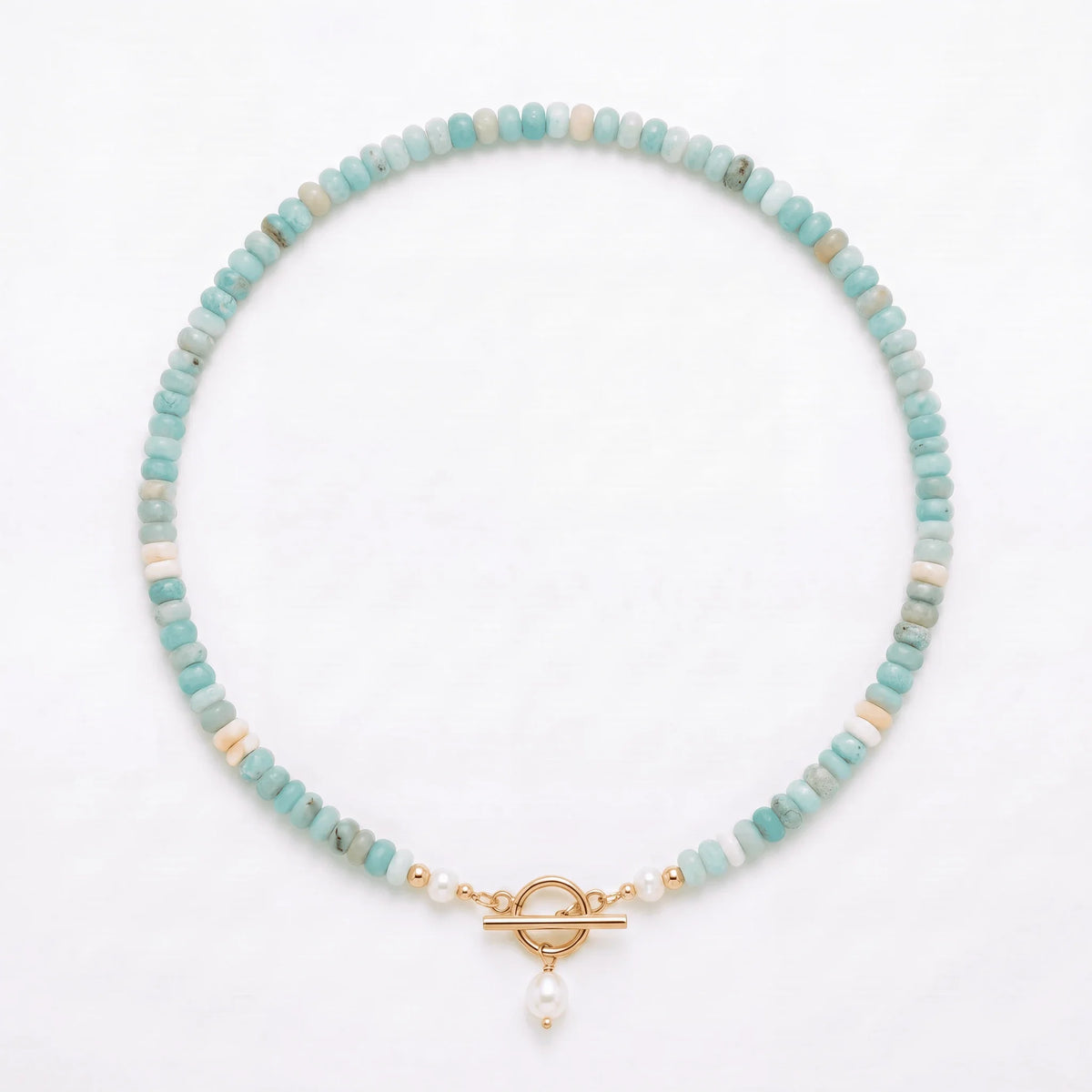 Turquoise Bead Pearl Necklace in gold laid flat on a white background