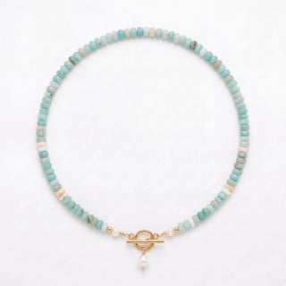 Turquoise Bead Pearl Necklace in gold laid flat on a white background