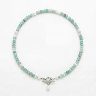 Turquoise Bead Pearl Necklace in silver laid flat on a white background