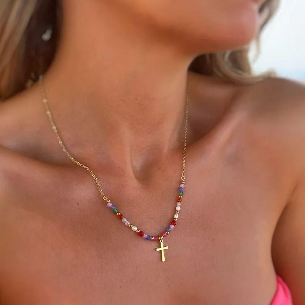 Gold beaded cross necklace worn