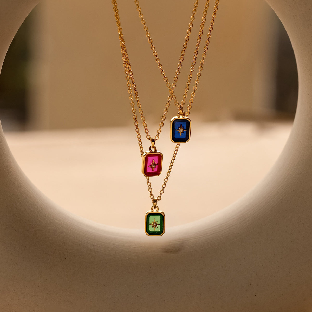 Three North Star birthstone pendants stacked