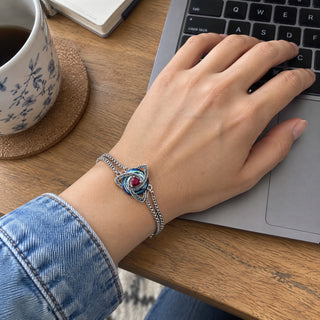 Wrist wearing the witch knot birthstone bracelet at a laptop