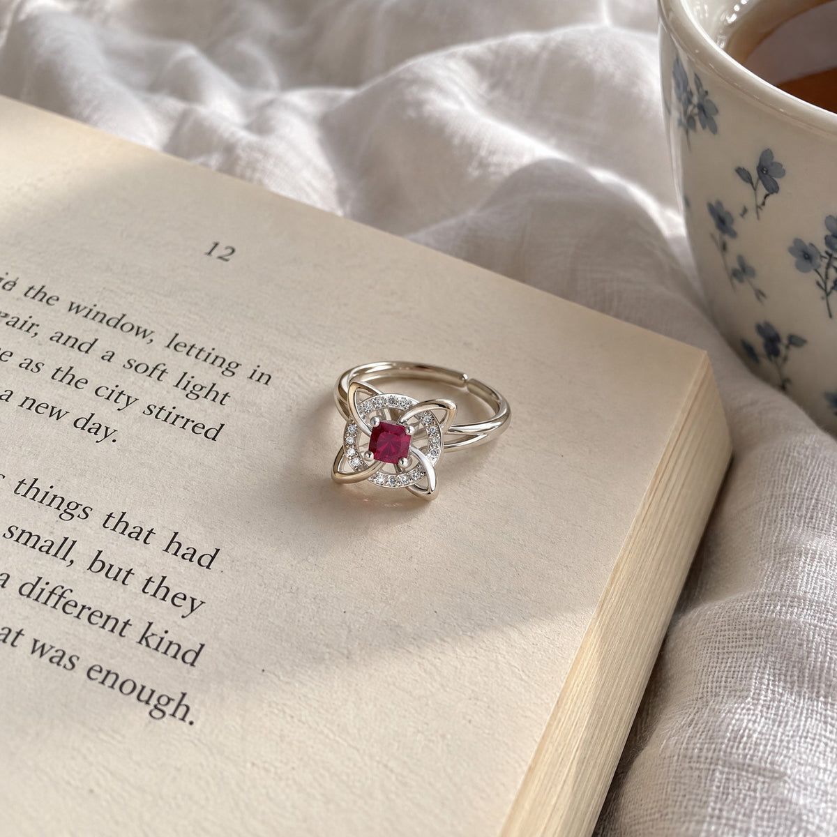Witch knot birthstone ring resting on an open book