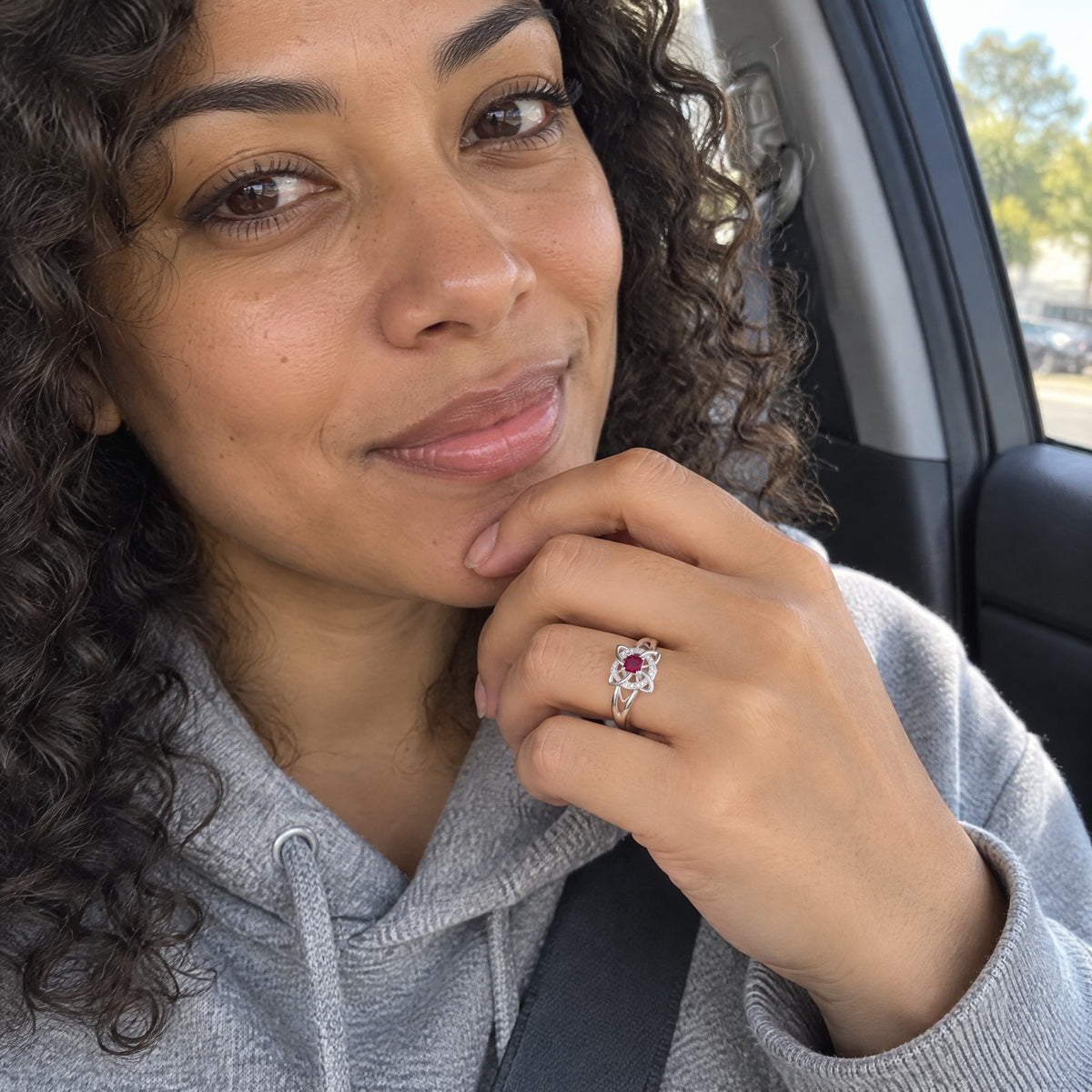 Woman in a car wearing the witch knot birthstone ring on her index finger