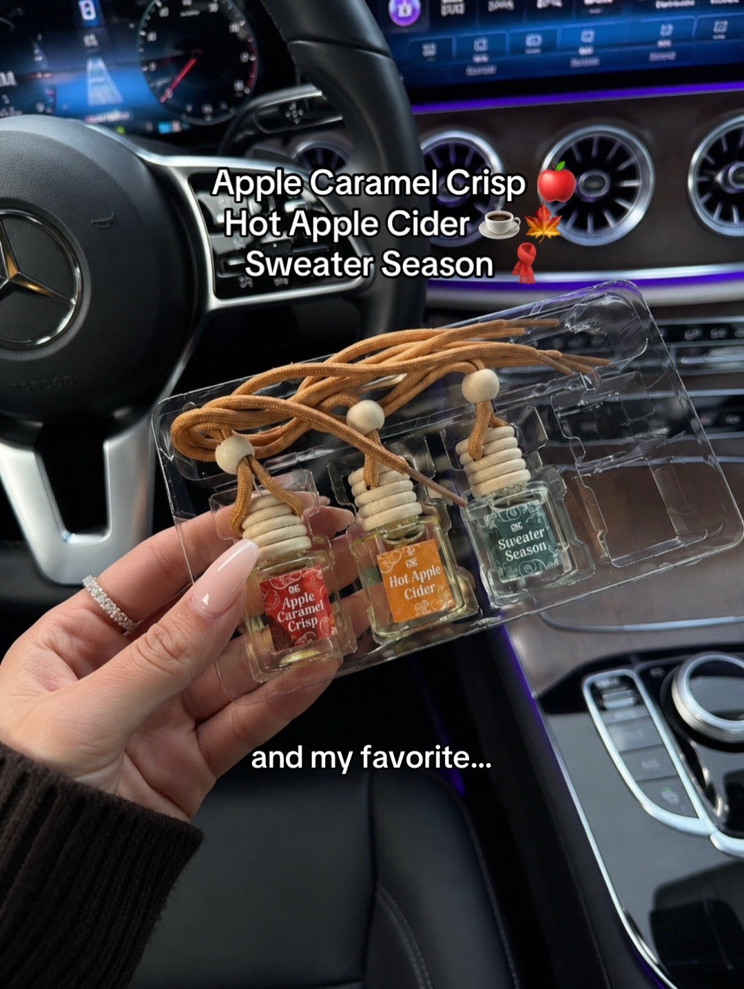 A hand holding the four fall car fresheners