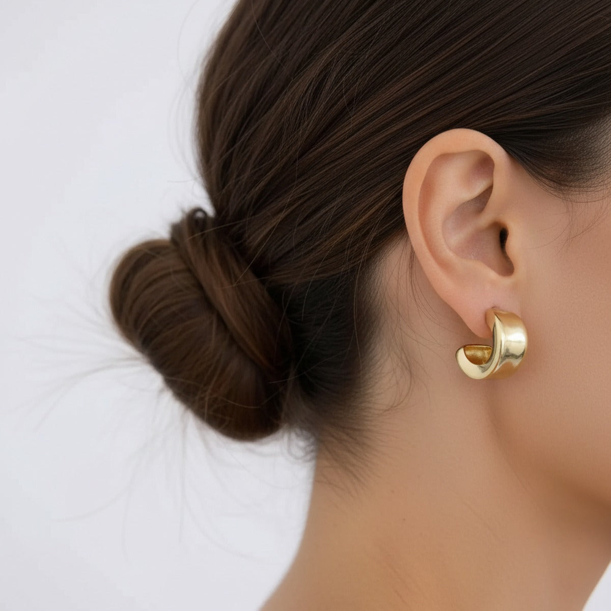 A thick gold hoop sitting perfectly level on the lobe