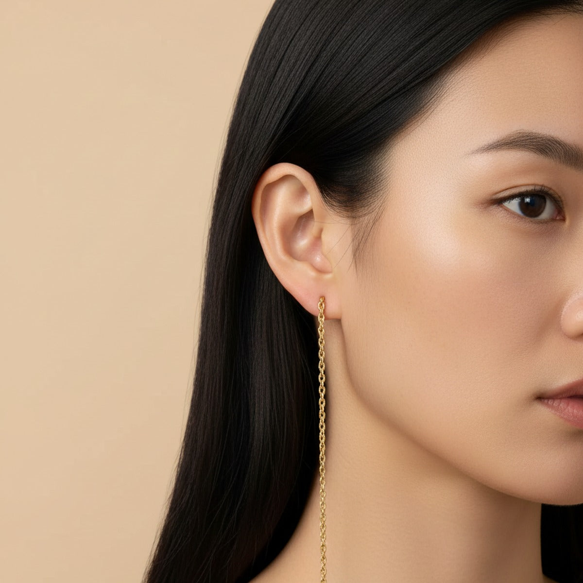A long gold chain earring falling perfectly vertical
