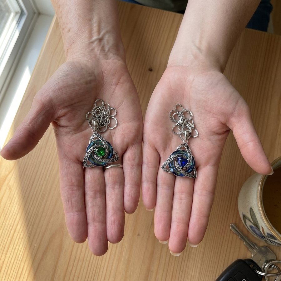 A mother's and a daughter's hands, each holding a witch knot with the other's birthstone