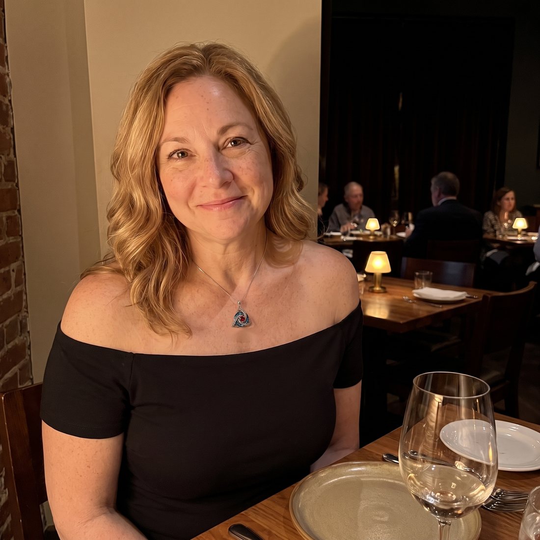A woman at dinner wearing the Witch Knot Birthstone Necklace