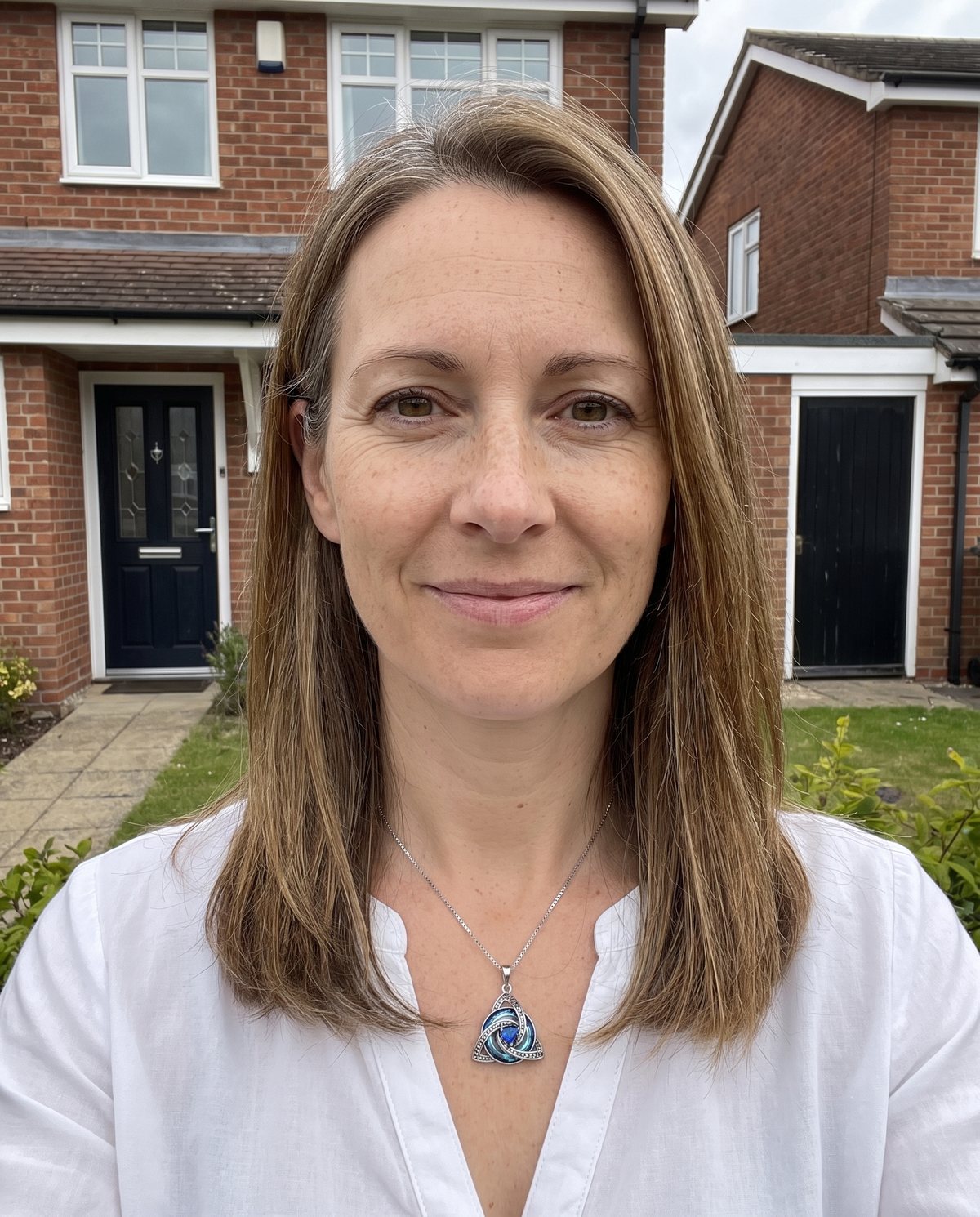 A woman outside her house wearing the witch knot birthstone necklace