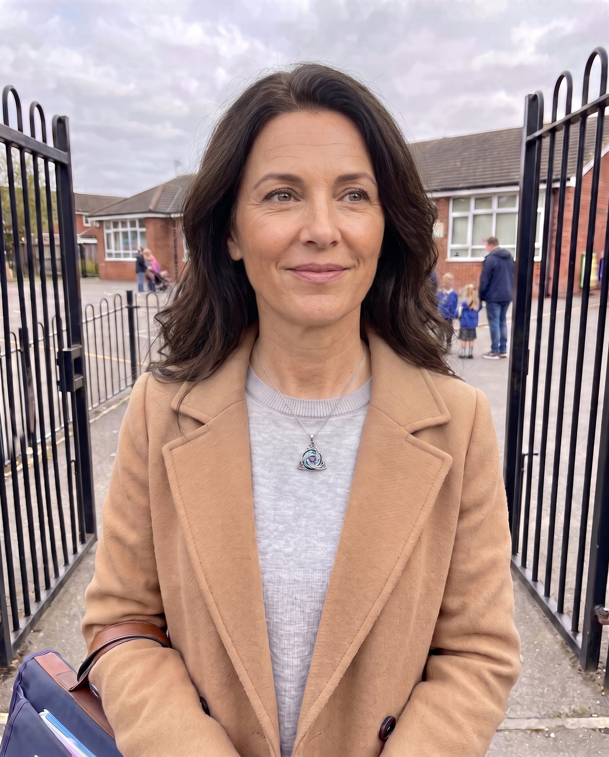 A woman at the school gates wearing the witch knot necklace