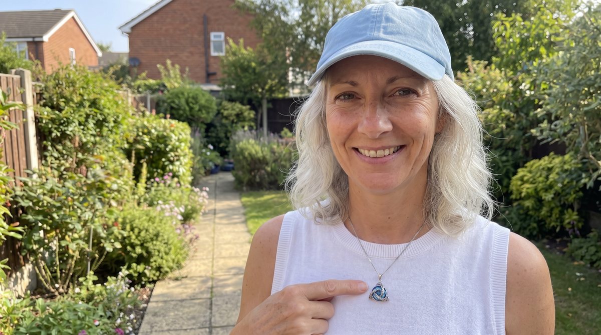 A woman pointing at her witch knot necklace
